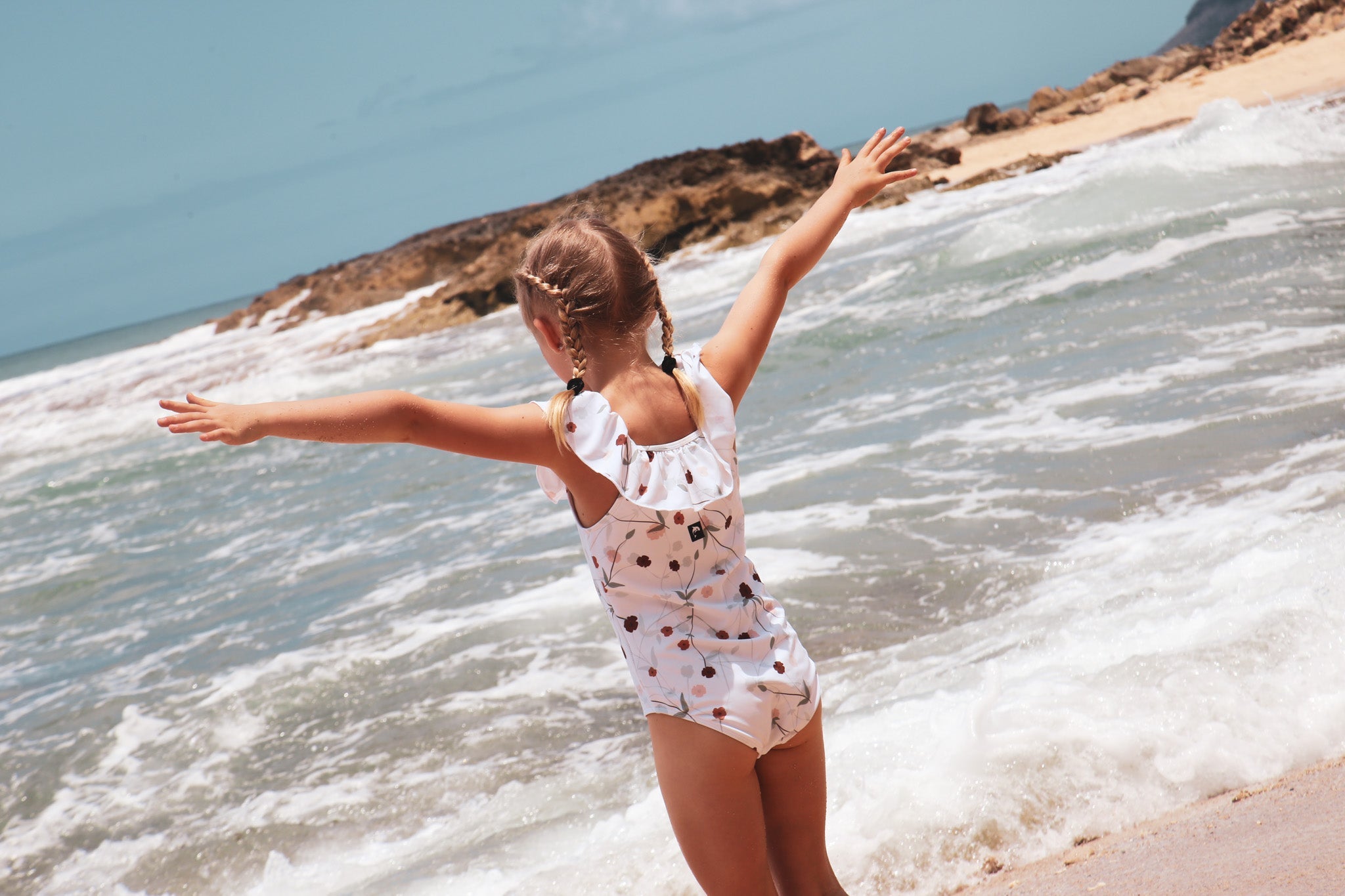 Girls wearing matching swim tops and bottoms from KidORCA at the beach