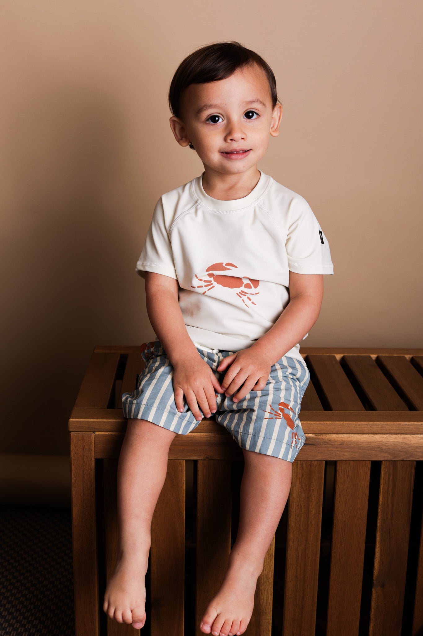 Child wearing crab-print short sleeve rashguard – side view
