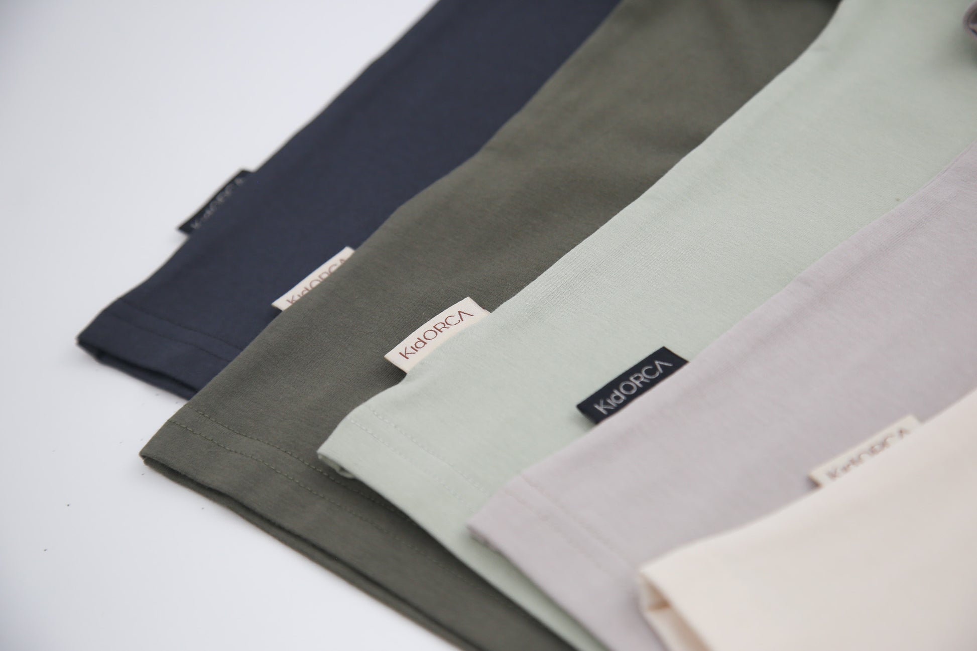 Close-up of organic cotton fabric on dusty olive kids tee