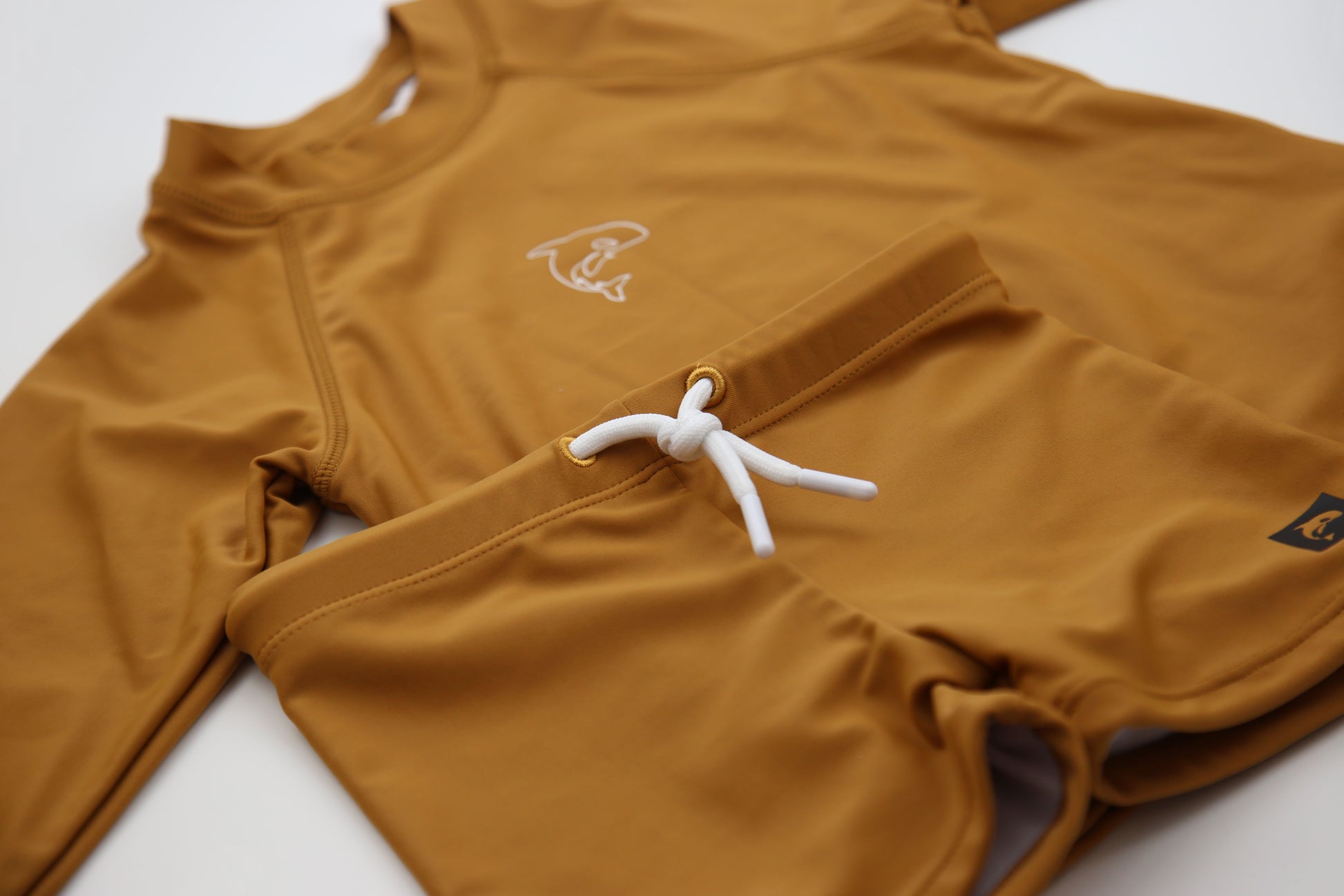 Close-up of UPF 50+ quick-dry recycled polyester fabric – ginger rashguard