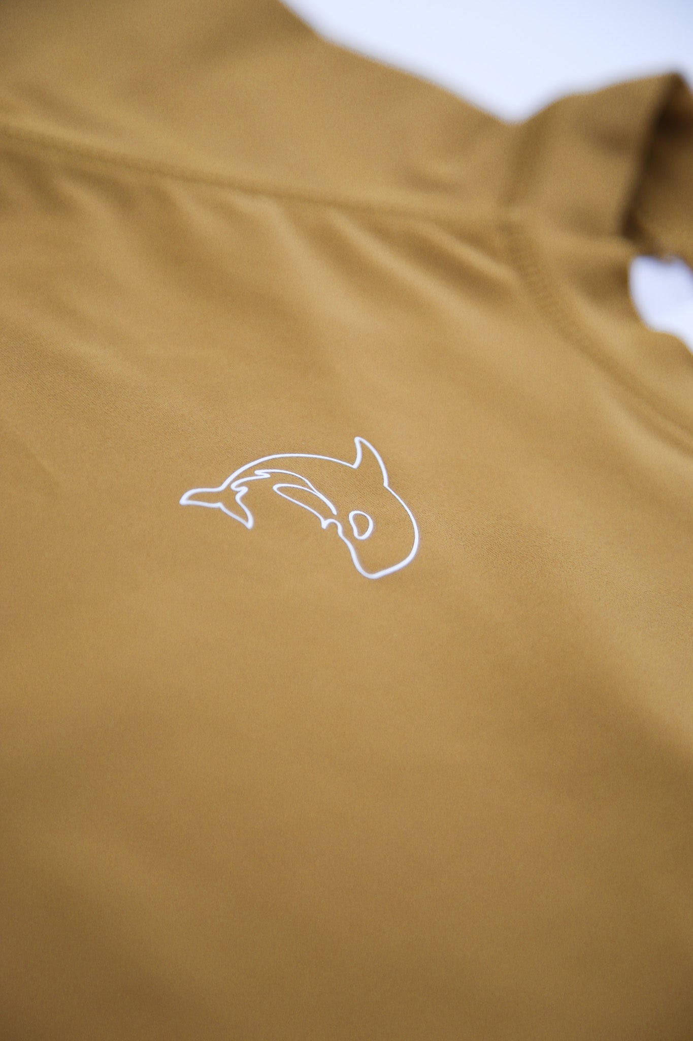 Close-up of UPF 50+ quick-dry recycled polyester fabric – ginger rashguard