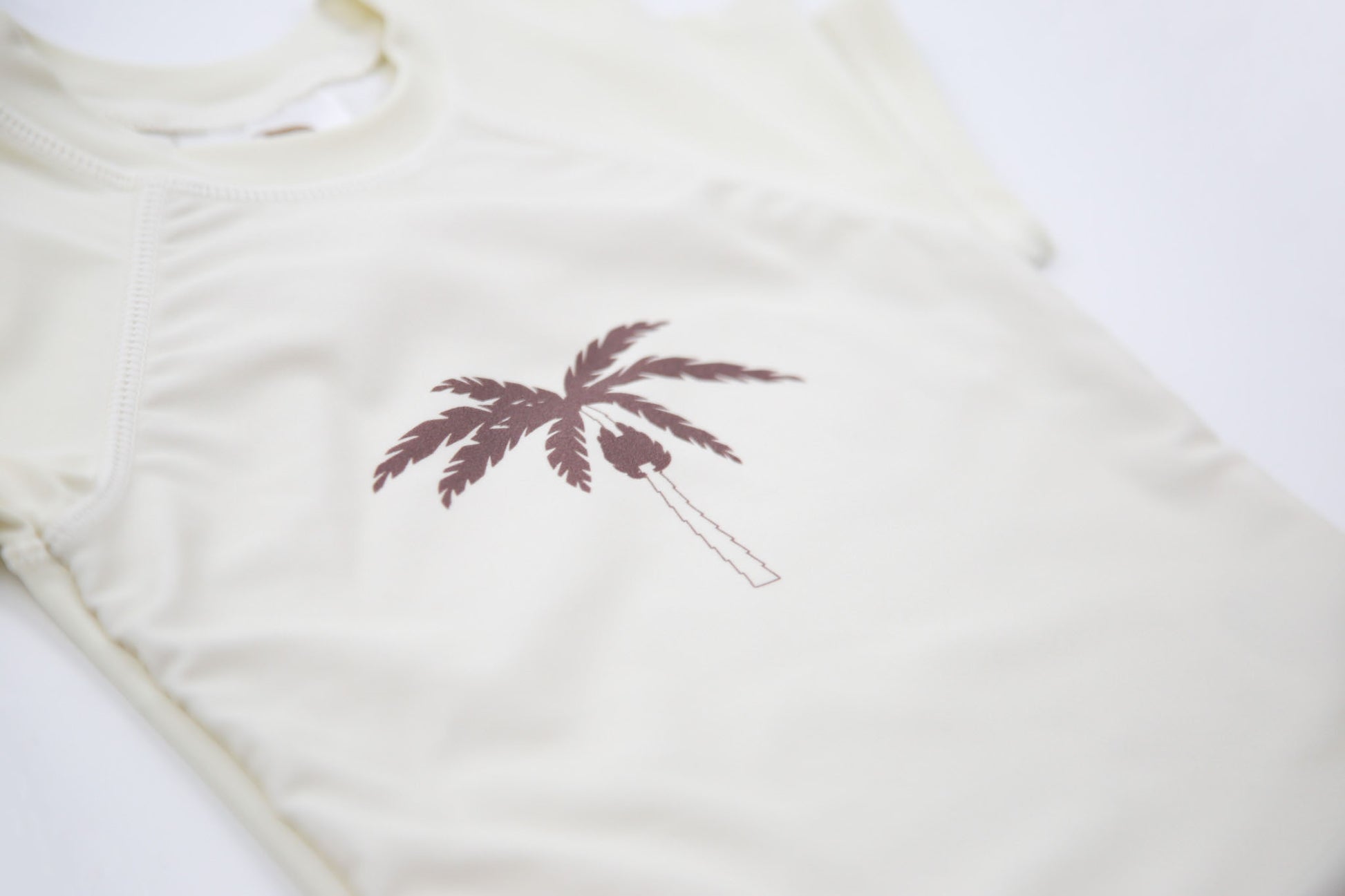 Close-up of UPF 50+ quick-dry recycled polyester – palm tree rashguard
