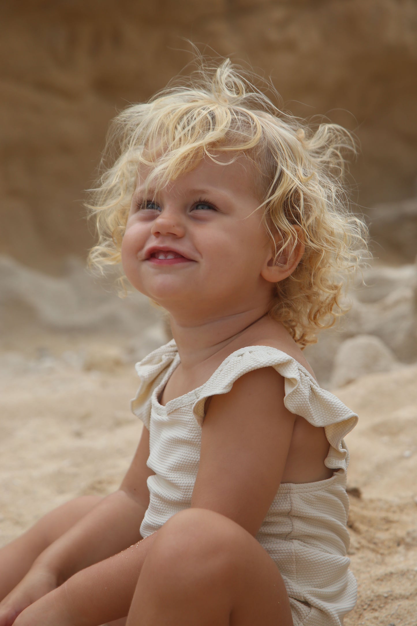 Girl playing in almond waffle weave swimsuit variant by KidORCA