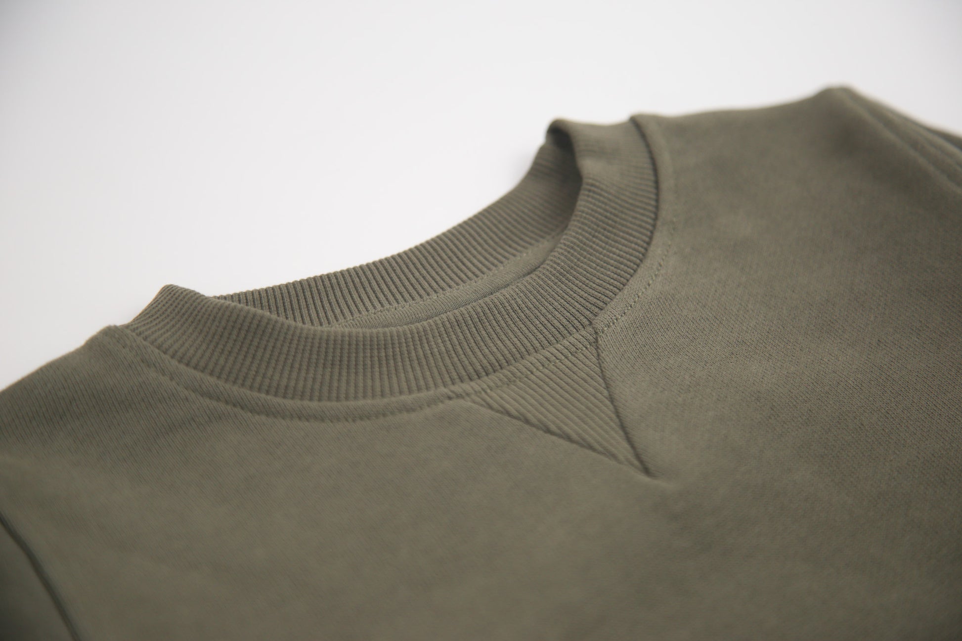 Close-up of french terry fabric and crewneck on dusty olive kids sweatshirt
