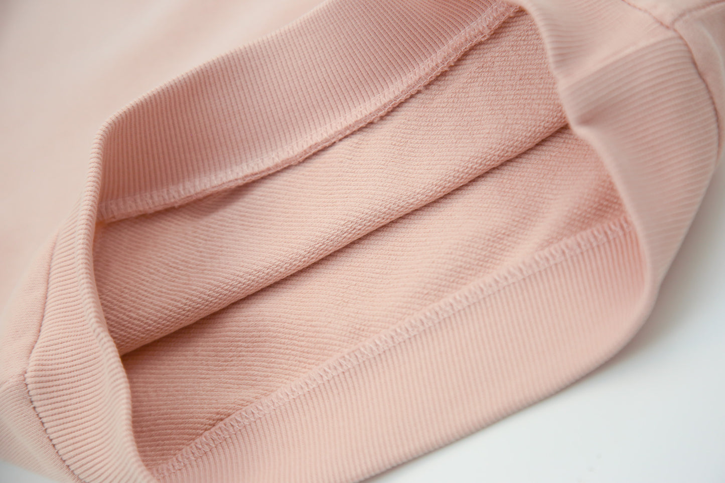 Close-up of organic french terry fabric texture – pale rose kids sweatpants