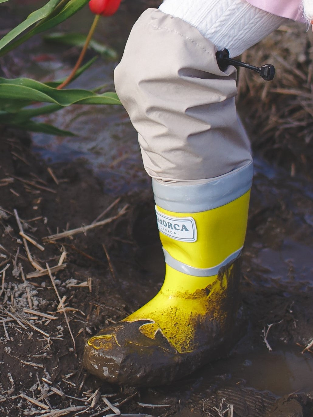 Child splashing in yellow rain boots with above-knee waders by KidORCA