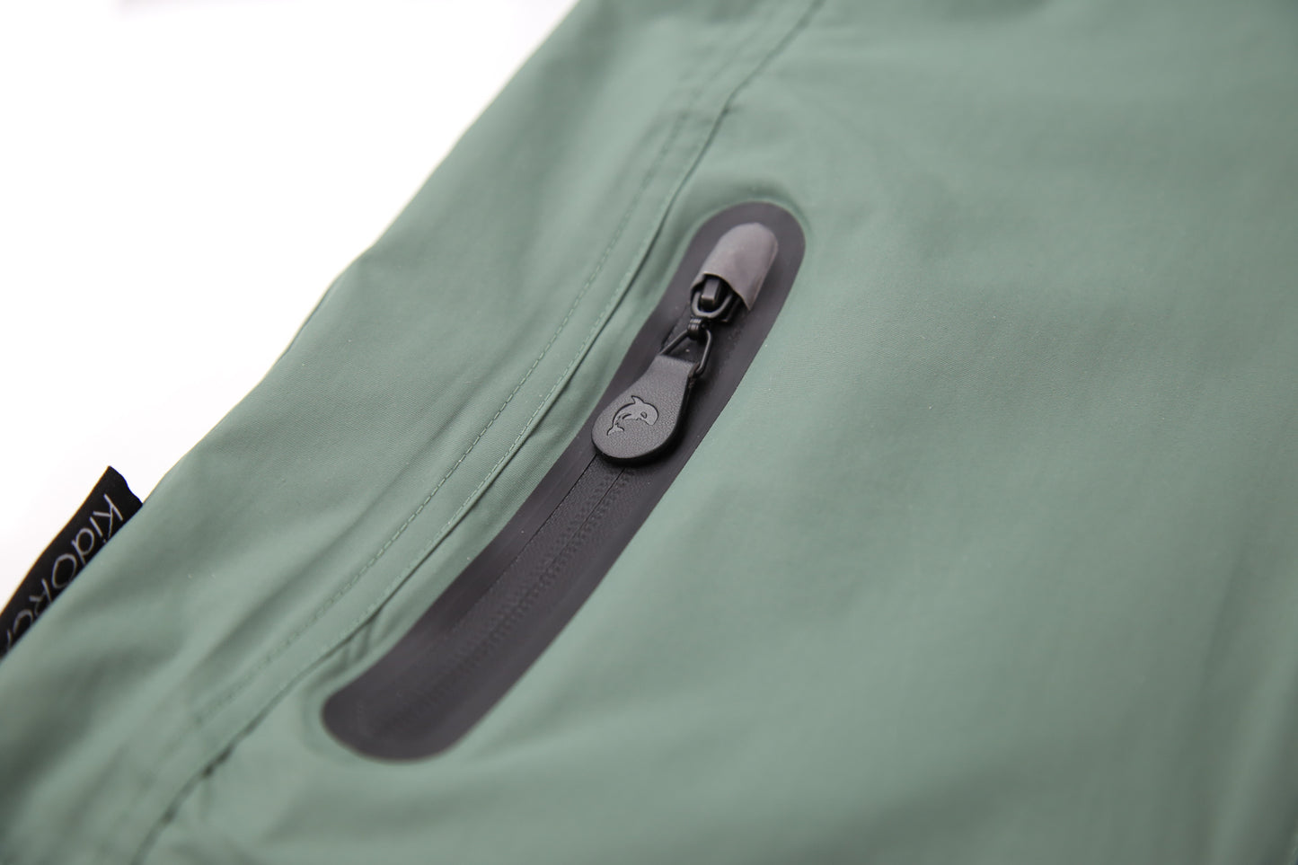 Close-up of waterproof zipper and high collar – olive rain jacket