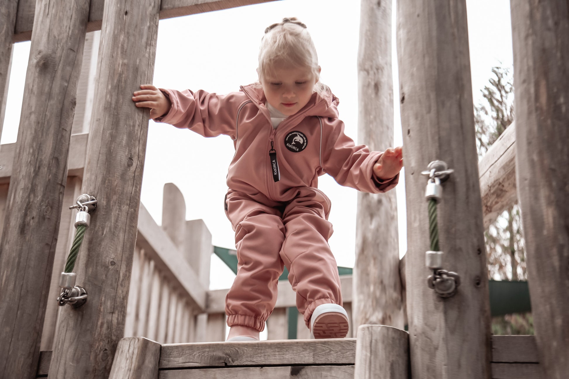 Child wearing ash-rose softshell overall by KidORCA