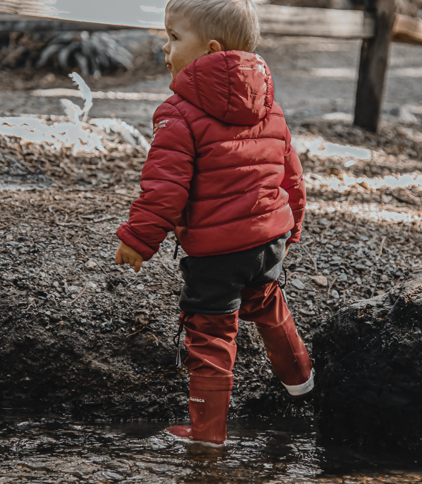 Child splashing in merlot rain boots with above-knee waders by KidORCA