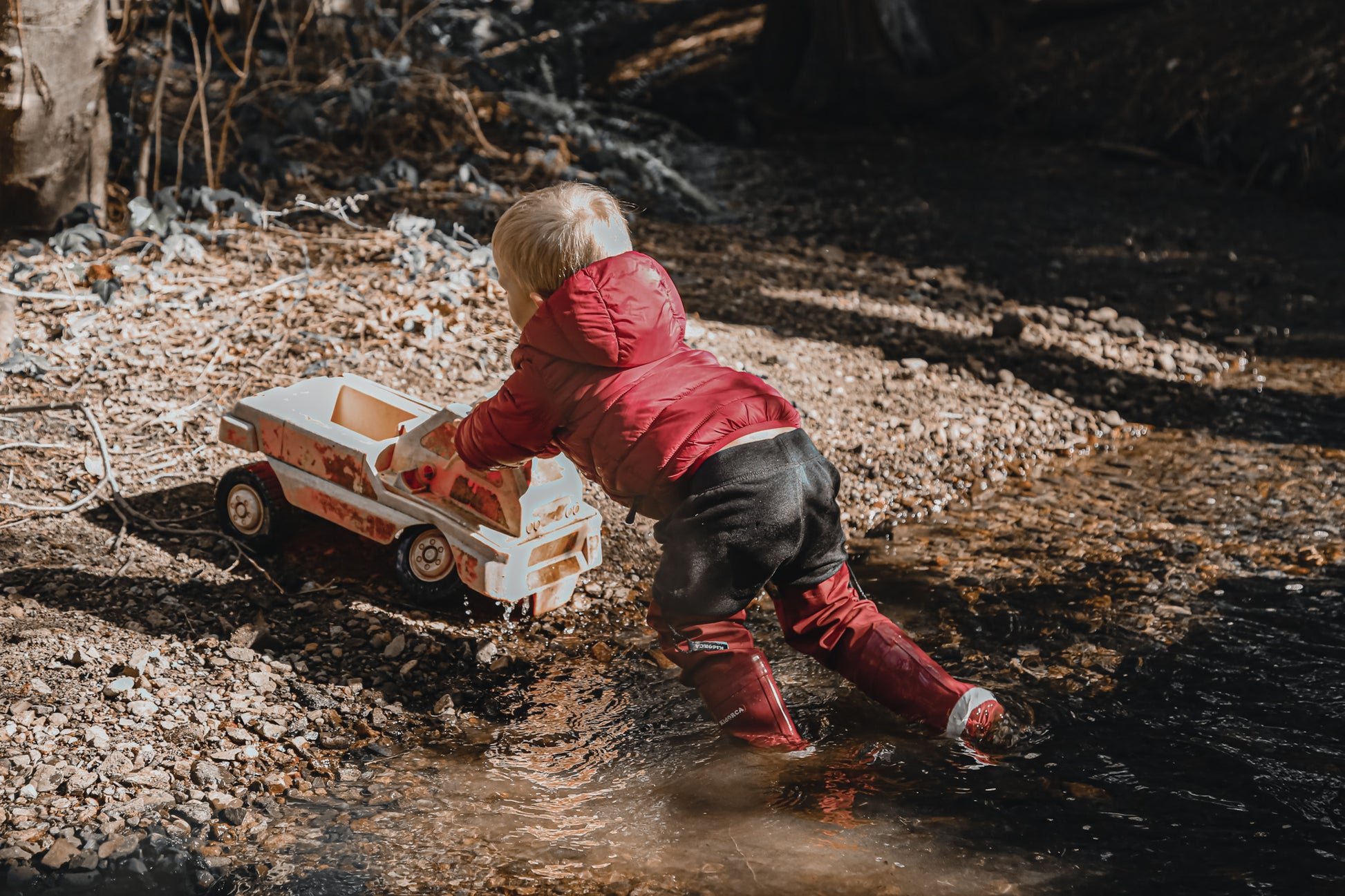 Child splashing in merlot rain boots with above-knee waders by KidORCA