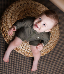 Baby playing in Trout Kalamata swim jumpsuit by KidORCA